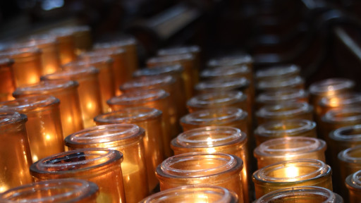 Picture of dozens of lit candles inside the Notre-Dame de Québec Basilica-Cathedral church.