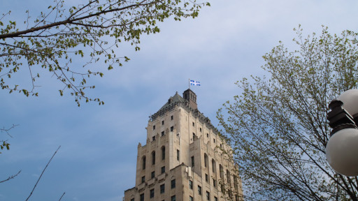 Quebec Provinical Flag flying atop an old building